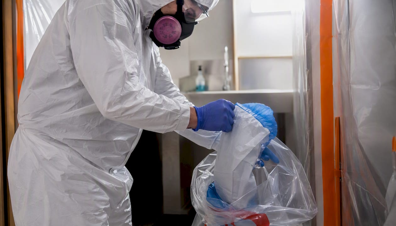 Worker removing protective gear in anteroom